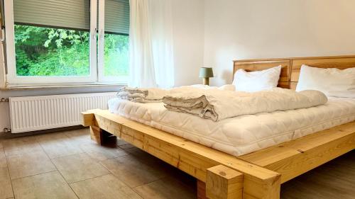 a bedroom with a large bed on a wooden bench at Sonnenblick Ferienwohnung in Wirsberg