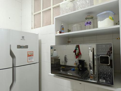 a microwave in a kitchen with a refrigerator at Apto no Centro de Petrópolis in Petrópolis