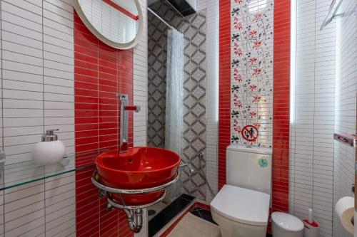 uma casa de banho com um lavatório vermelho e um WC. em Apartment in Saranda em Saranda