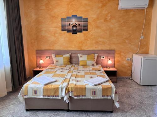 1 dormitorio con 1 cama grande y 2 mesitas de noche en Guest House Nikolovi, en Lozenets