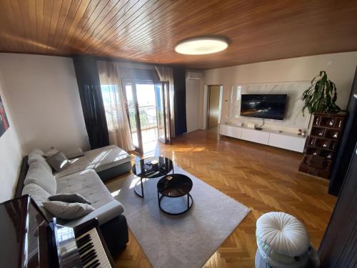 a living room with a couch and a tv at SLAVANTE RESIDENCE in Rijeka