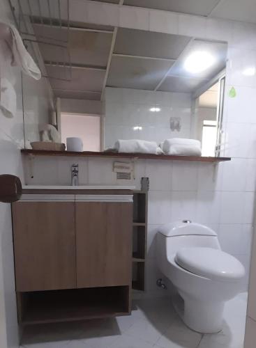 a bathroom with a toilet and a sink and a mirror at Hotel Laureles 70 Medellín in Medellín