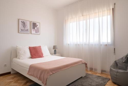 a white bedroom with a bed and a window at KING SIZE Bed with Air Conditioning near the BEACH & FREE Street Parking in Canidelo