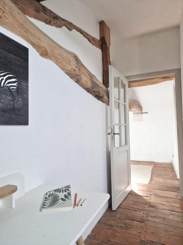 Cette chambre est dotée de murs blancs et de poutres apparentes. dans l'établissement Domaine Du Tertre, à Saint-Romain-la-Virvée
