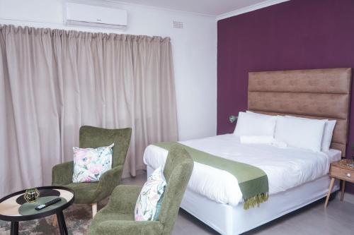 ein Hotelzimmer mit einem Bett und einem Stuhl in der Unterkunft Pristine Guest Apartments in Mthatha