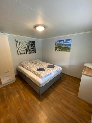 a bedroom with a bed and paintings on the walls at Two bedroom apartement in Sogndal