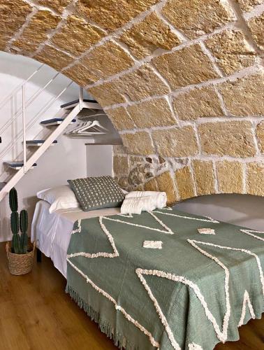 a bedroom with a bed and a brick wall at Essential in Polignano a Mare