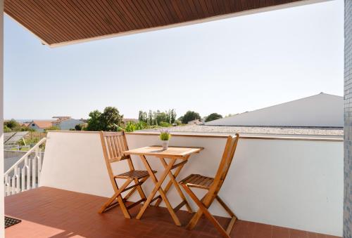 a balcony with a table and two chairs at KING SIZE Bed with Air Conditioning near the BEACH & FREE Street Parking in Canidelo