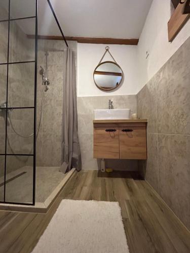 a bathroom with a shower and a sink and a mirror at RELAX HOME Visoko in Visoko