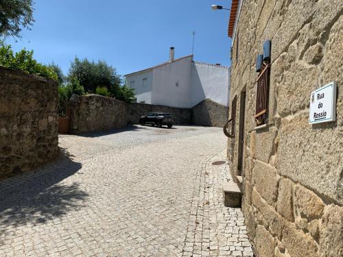 a stone alley with a car parked next to a building at Encanto Casa com Spa Jacuzzi Open Space in Tinalhas