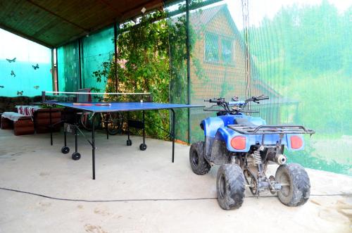 a four wheeler parked next to a ping pong table at Gostynnyi Dvir u Marichky in Lazeshchyna