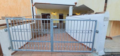a gate in front of a building with a staircase at Residenza il Filo in Orosei