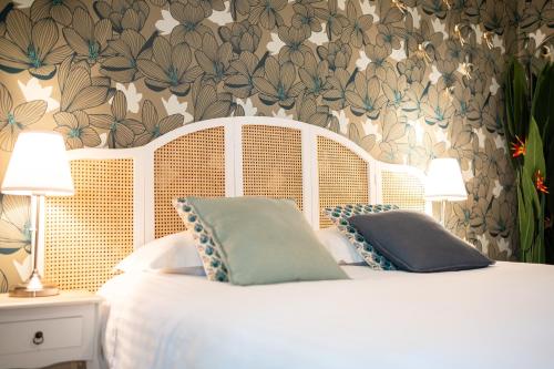 ein Schlafzimmer mit einem weißen Bett mit Blumentapete in der Unterkunft Villa Vichéia - Appartement 31 in Vichy