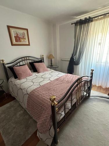 a bedroom with a large bed with pink pillows at Casa Portas da Cruz in Almeida