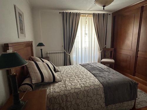 a bedroom with a bed and a window at Casa Portas da Cruz in Almeida
