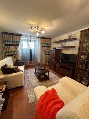 a living room with a couch and a tv at Casa Portas da Cruz in Almeida