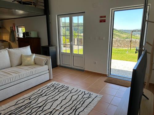 a living room with a couch and a sliding glass door at Casal dos Mochos in Sobral de Monte Agraço