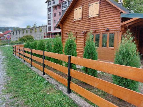 una valla de madera frente a una casa en Zara Chalet en Kolašin
