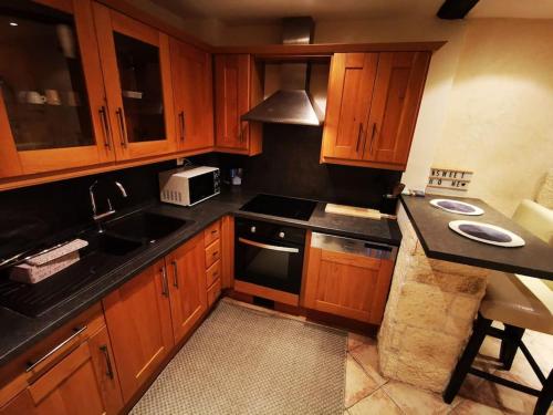 une cuisine avec des placards en bois et des comptoirs noirs dans l'établissement Antibes, à Antibes