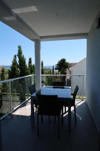 een tafel en stoelen op een balkon met uitzicht bij Apartments Villa Prima in Privlaka