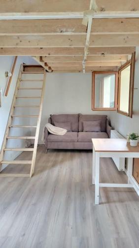 a living room with a couch and a staircase at Maisonnette en duplex - jardin in Noisy-le-Grand