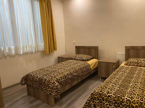 科布萊蒂的住宿－Anna，一间设有两张带豹纹床单的床的房间