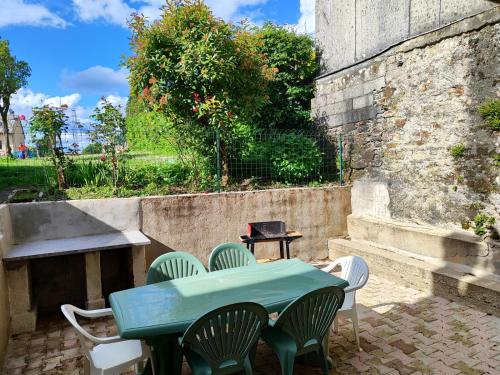 une table et des chaises vertes sur la terrasse dans l'établissement Maison de village, à Saint-Pierre-de-Trivisy