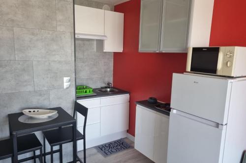 Elle comprend une petite cuisine équipée d'un réfrigérateur blanc et d'une table. dans l'établissement Naturiste Cap d'Agde Port Nature 874, au Cap d'Agde