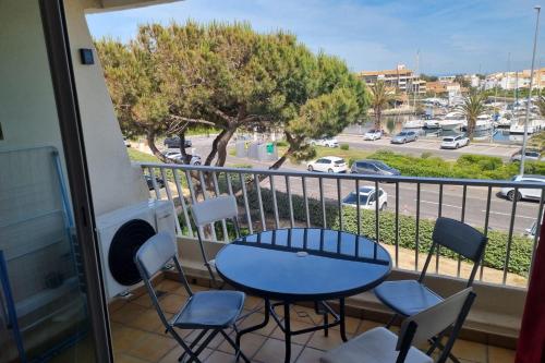 d'un balcon avec une table et des chaises et une vue sur le parking. dans l'établissement Naturiste Cap d'Agde Port Nature 874, au Cap d'Agde