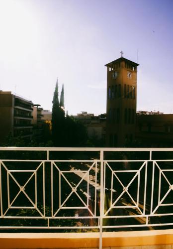 a building with a clock tower in a city at Gk Suites-Constantin view , auto check-in 24h in Larisa