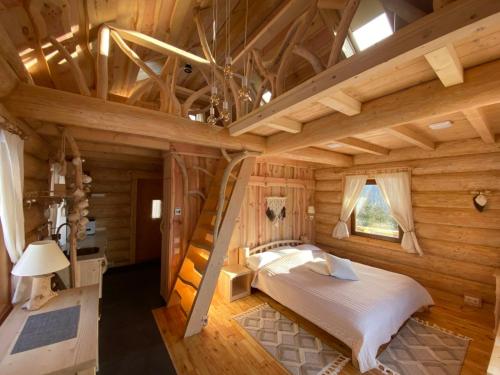 a log cabin bedroom with a bed and a ladder at To Lem Ande in Lumshory