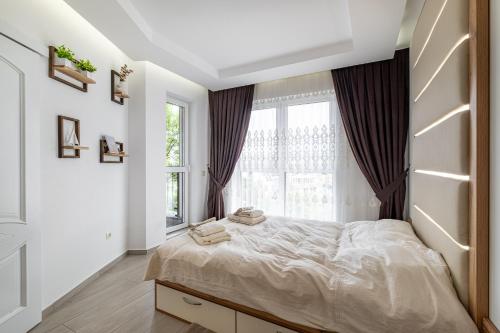 a bedroom with a large bed and a window at Boutique 1 bedroom apartment with Private Parking and Port View in Varna City