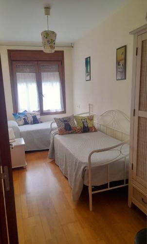 a bedroom with a bed and a couch in it at Jardines del Sella in Cangas de Onís