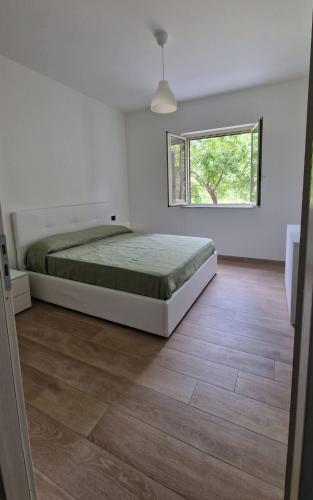 un dormitorio con una cama y una ventana en Appartamenti Palinuro Isca, en Palinuro
