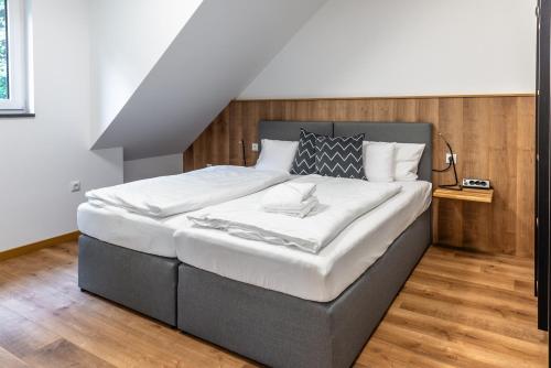a bedroom with a large bed with white sheets at Heilsteinlodge in Einruhr
