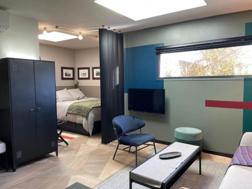 une chambre avec un lit, une télévision et un canapé dans l'établissement Studio indépendant proche Paris - Chromatic Stella Luxe, calme et volupté, à Orly