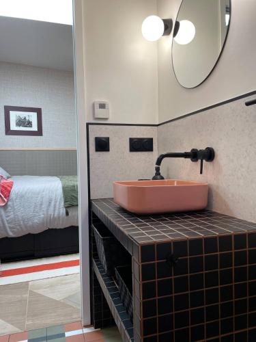 une salle de bain avec un lavabo et un lit dans l'établissement Studio indépendant proche Paris - Chromatic Stella Luxe, calme et volupté, à Orly