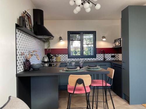 une cuisine avec une table et des chaises roses dans l'établissement Studio indépendant proche Paris - Chromatic Stella Luxe, calme et volupté, à Orly