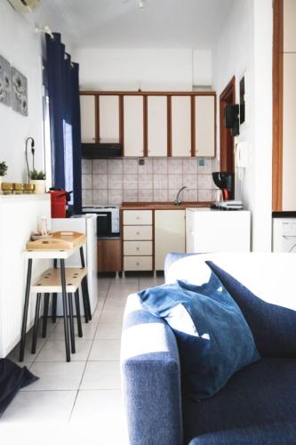 a kitchen and a living room with a couch and a table at Gk Suites-Constantin view , auto check-in 24h in Larisa