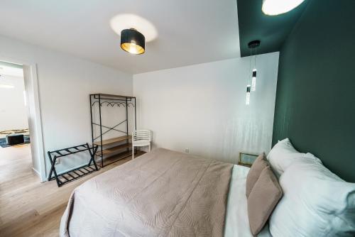 ein Schlafzimmer mit einem großen Bett mit einer grünen Wand in der Unterkunft L'Emeraude in Saint-Brieuc