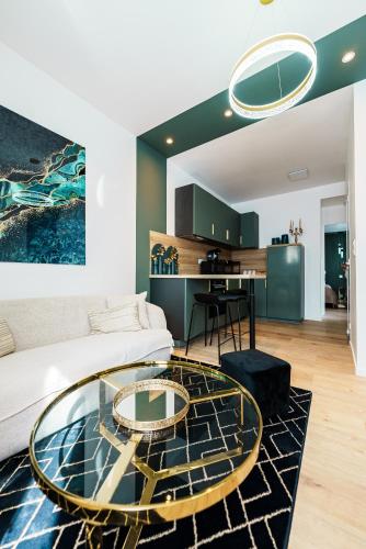 un salon avec un canapé et une table en verre dans l'établissement L'Emeraude, à Saint-Brieuc