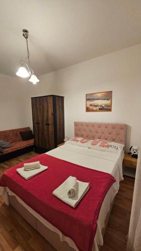 a bedroom with a large bed with two towels on it at Kuća NIKA in Tribunj