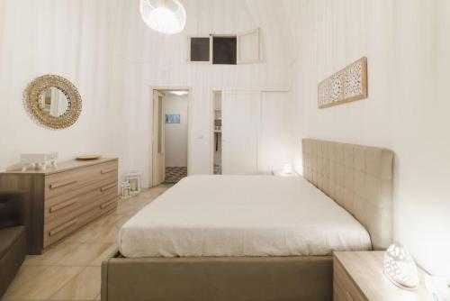 a white bedroom with a large bed and a dresser at Historical big & quite house in the mid of Salento in Cutrofiano