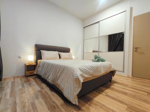 a bedroom with a large bed and a wooden floor at SoulHealingPlace Galacity 2BR 2Bed Apartment in Kuching