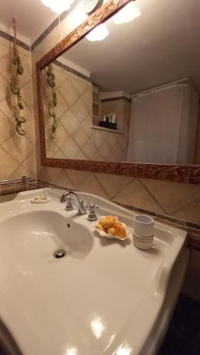 une salle de bain avec un lavabo et un miroir dans l'établissement Casa MAFALDA, à Gaète