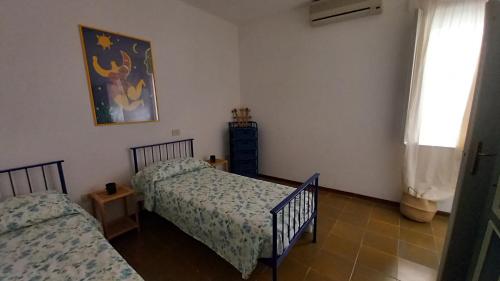 une chambre avec deux lits jumeaux et une fenêtre dans l'établissement Casa MAFALDA, à Gaète