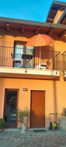 a house with a balcony with an umbrella at B&B La Casa di Giuliana in Cermignano