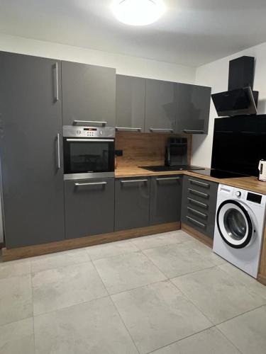 a kitchen with a stove and a washing machine at Apartament pod ŚWIERKIEM in Krupski Młyn