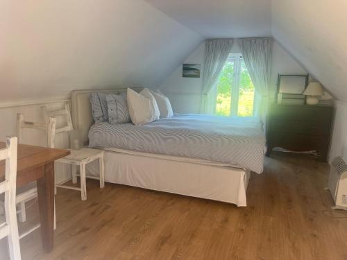 a bedroom with a bed and a table and a window at 4 Lisle court cottages in Lymington