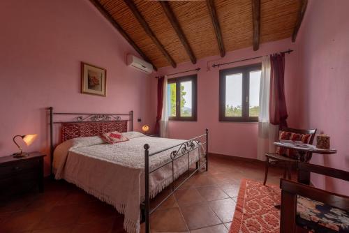 a bedroom with a bed in a room with pink walls at Tenuta Don Ballore in Galtellì